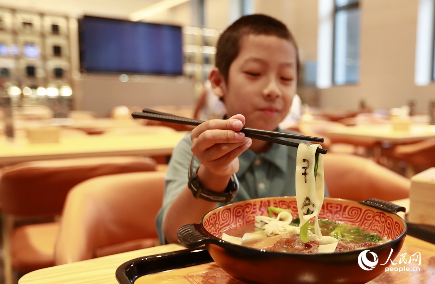 殷墟博物館推出的甲骨文面深受游客喜愛。人民網(wǎng)記者 慎志遠(yuǎn) 攝