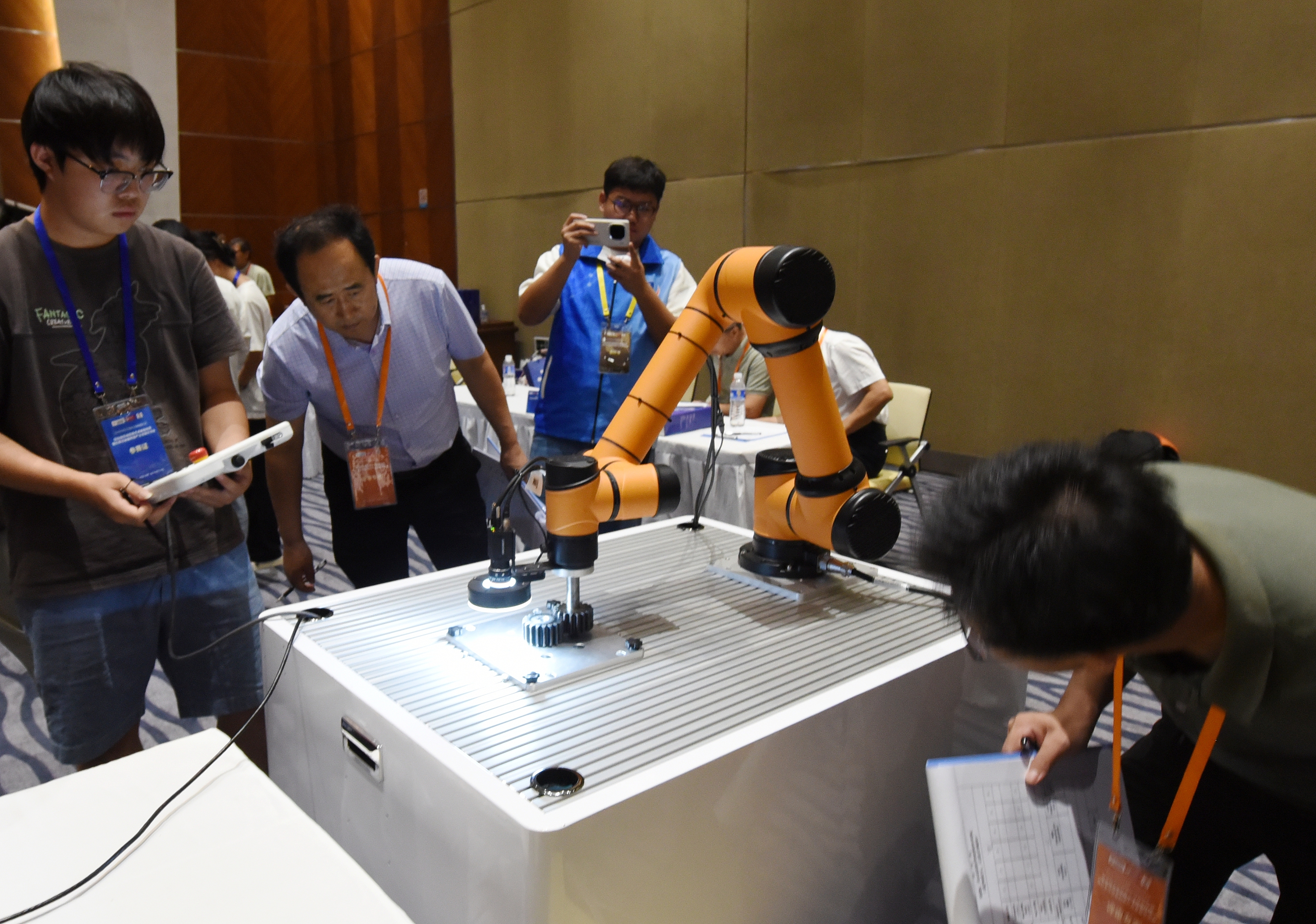 2025年中國大學(xué)生機(jī)械工程創(chuàng)新創(chuàng)意大賽智能精密裝配賽京津冀魯聯(lián)賽現(xiàn)場(chǎng)，評(píng)委對(duì)參賽選手進(jìn)行實(shí)操調(diào)試評(píng)比。